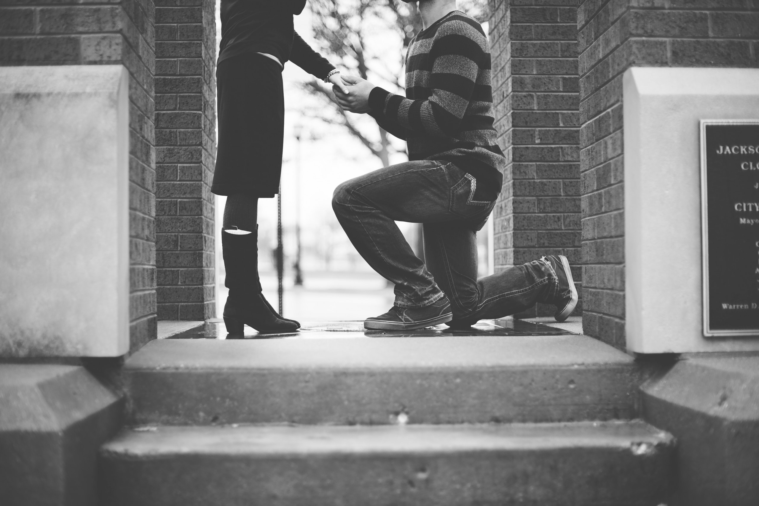 A man on one knee proposing to a woman