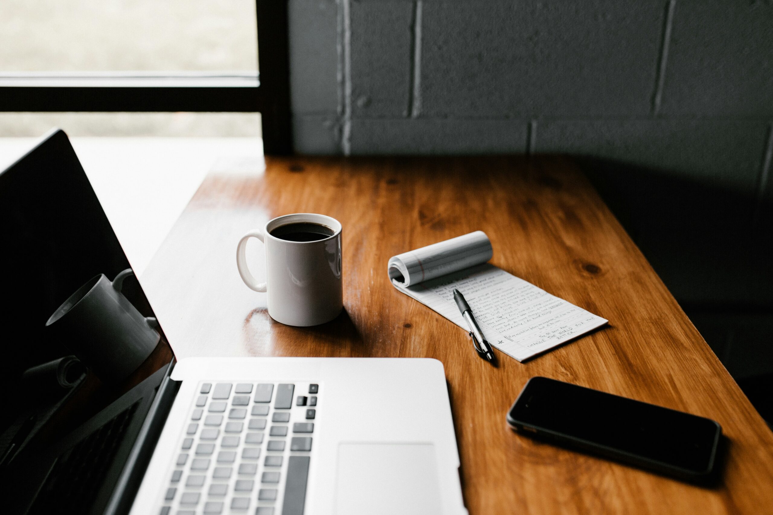 A laptop and notepad sitting on a desk, representing EKB, a Vancouver full-service business law firm